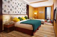 a bedroom with a large bed with yellow and green pillows at Beijing Hotel Minsk in Minsk