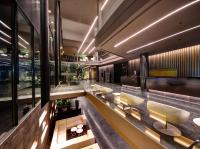 a lobby with a long counter with yellow chairs at Olivia Balmes Hotel in Barcelona