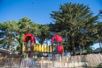 une aire de jeux colorée derrière une clôture en bois dans l&#39;établissement Camping Les Grenettes, à Sainte-Marie de Ré