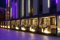 a building with people sitting at tables at night at Renion Park Hotel in Almaty