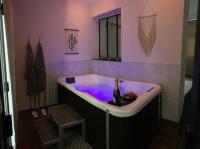 La salle de bains est pourvue d&#39;une baignoire avec un mur violet. dans l&#39;établissement 6 place de la détente, à Saint-Venant