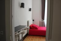 a bedroom with a red bed and a flat screen tv at Les Cariatides in Lille
