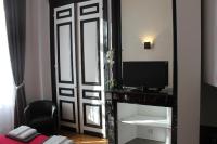 a room with a door with a television and a mirror at Les Cariatides in Lille
