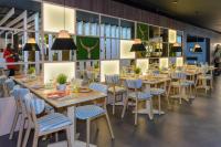 Un comedor con mesas, sillas y luces. en Hostal Torrejón, en Torrejón de Ardoz