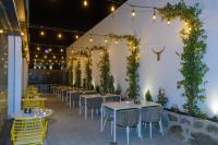 un restaurante con mesas, sillas y vides en Hostal Torrejón, en Torrejón de Ardoz