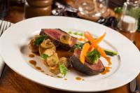 a plate of food with meat and vegetables on a table at Capitán Suizo Beachfront Boutique Hotel in Tamarindo