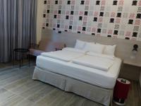 a bed with white sheets and pillows in a room at KLA B&amp;B in Kaohsiung