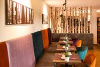 una fila di tavoli in un ristorante con sedie colorate di premium by GS Hotel a Monaco