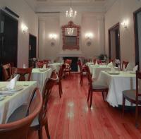 een restaurant met witte tafels en stoelen en een kroonluchter bij Villa Maria Cristina Hotel in Guanajuato