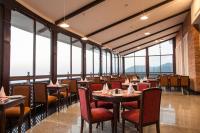 a restaurant with tables and chairs and large windows at Chandragiri Hills Resort Kathmandu-Luxury in the Clouds in Thānkot