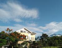 a white house with trees and a cloudy sky at Celine&#39;s B&amp;B in Fenglin