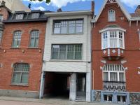 a red brick building with a garage at Hollandia City House in Hasselt