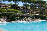 a swimming pool with chairs and umbrellas at Résidence Marina Di Santa Giulia in Porto-Vecchio