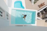 a person swimming in a swimming pool in a house at Aspaki by Art Maisons in Oia