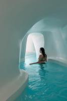 a woman is sitting in a pool of water at Aspaki by Art Maisons in Oia