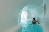 a woman sitting in a pool of water in an igloo at Aspaki by Art Maisons in Oia