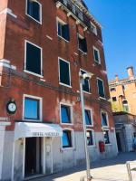 a large brick building with a clock on it at Hotel Vecellio Venice on the Lagoon in Venice