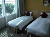 two beds sitting in a room with a window at In Young Hotel in Kaohsiung