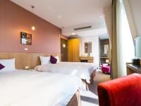 a hotel room with two beds and a red chair at In Young Hotel in Kaohsiung