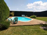 a pool with a deck and two chairs next to it at Les Bessonnes in Saint-Georges-Haute-Ville