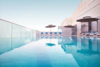 a pool with chairs and umbrellas in a building at Treppan Hotel & Suites By Fakhruddin in Dubai