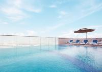 a swimming pool with chairs and an umbrella at Treppan Hotel & Suites By Fakhruddin in Dubai