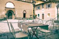 a group of tables and chairs in front of a building at PALAZZO DE' ROSSI HOTEL in Sasso Marconi