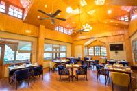 Un restaurante con mesas y sillas en una sala. en Regenta Inn by Riverside Manali, en Manali