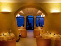 a restaurant with tables and chairs and windows at Hotel Villa Giulia in Gargnano