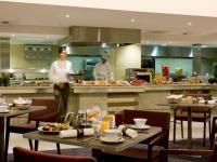 two chefs in a restaurant kitchen with tables at Sofitel London Heathrow in Hillingdon