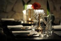 a table with a vase with a rose in it at Caportigia Boutique Hotel in Siracusa