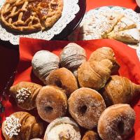 a plate of donuts and other pastries on a table at Palazzetto Rosso - Art Hotel in Siena