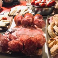 a table topped with different types of bread and meats at Palazzetto Rosso - Art Hotel in Siena