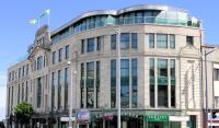 Un gran edificio con una bandera encima. en The Grand Hotel, en Swansea