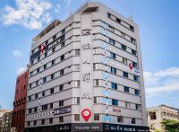 un edificio blanco alto con signos asiáticos en él en Traveller Inn Tiehua Cultural and Creative Hotel II, en Taitung