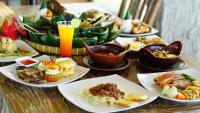 Una mesa llena de platos de comida sobre una mesa. en Sunsethouse Lombok, en Senggigi 