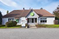 a small white house with a gas station at Campanile Chanas in Chanas