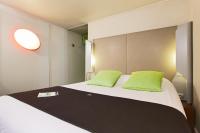 a bedroom with a large bed with green pillows at Campanile Chanas in Chanas