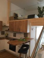a kitchen with wooden cabinets and a black chair at Serviced Apartement Sonnleitner in Furth