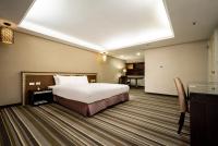 a hotel room with a bed and a desk at Yoyo Hotel in Chiayi City