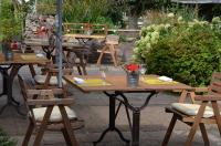 un grupo de mesas y sillas con flores. en Les Bruyeres, en Plélan-le-Grand