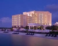 a large building with chairs in front of it at night at Traders Hotel, Abu Dhabi in Abu Dhabi