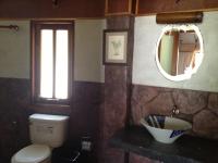 a bathroom with a toilet and a mirror at Malibu Beach Bungalows in Chaloklum