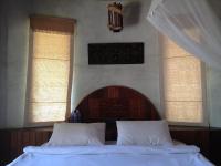 a bed with two white pillows in a bedroom with two windows at Malibu Beach Bungalows in Chaloklum
