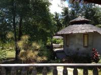 a small hut with a thatched roof in a garden at Malibu Beach Bungalows in Chaloklum