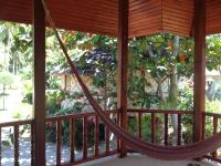 a hammock on a porch with a tree at Malibu Beach Bungalows in Chaloklum