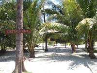 a sign on a palm tree on a beach at Malibu Beach Bungalows in Chaloklum