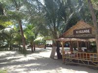 a small building on the beach with palm trees at Malibu Beach Bungalows in Chaloklum