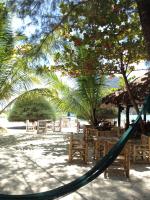 a hammock on a beach with chairs and umbrellas at Malibu Beach Bungalows in Chaloklum