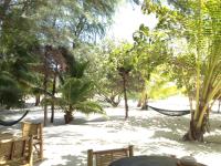 a hammock in the middle of a beach with trees at Malibu Beach Bungalows in Chaloklum